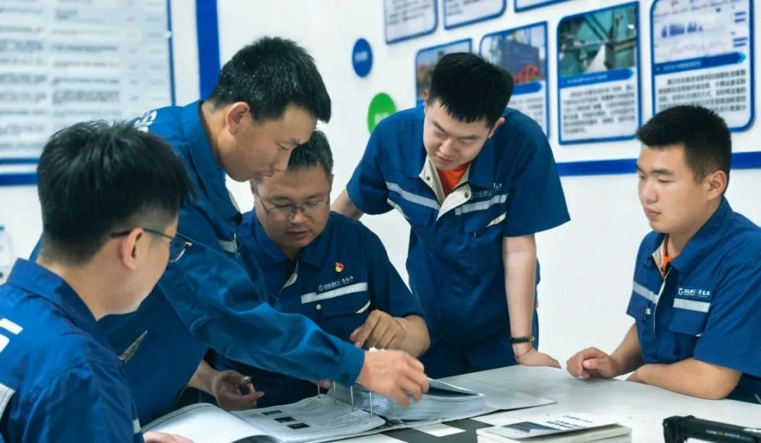 Господин Сонг (слева 3) со своими коллегами обсуждает возможность решения на встрече.